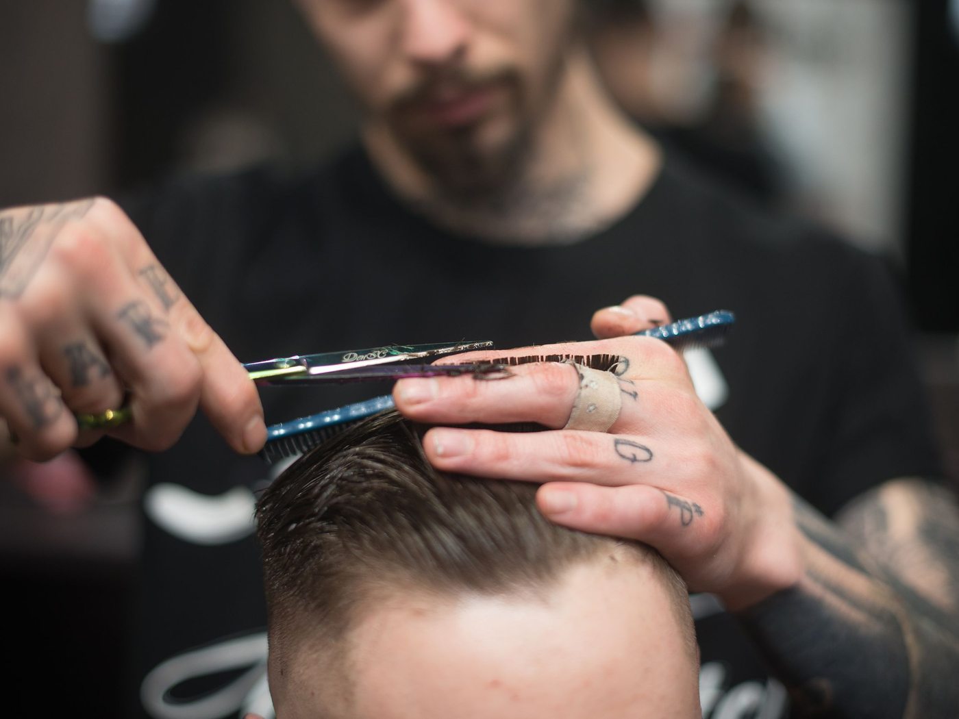 A barber blending a fade with clippers